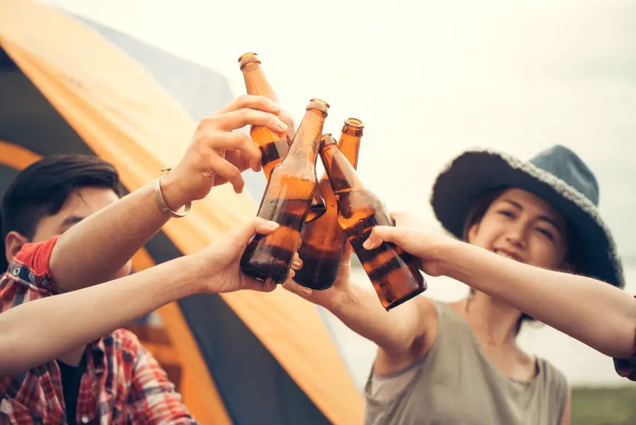 Group of people cheering with beer bottles