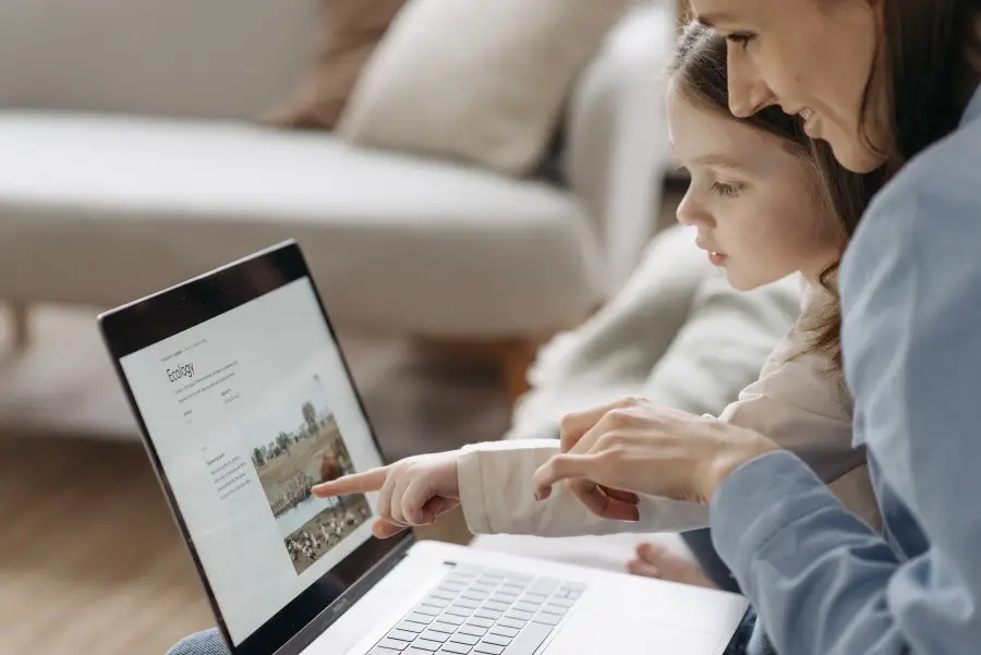 child showing mother something on computer screen