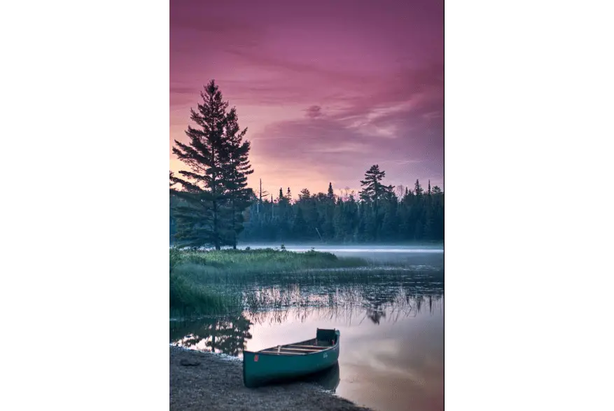 Canoe on the shore of the lake in Ely Minnesota under a lavender-colored sky