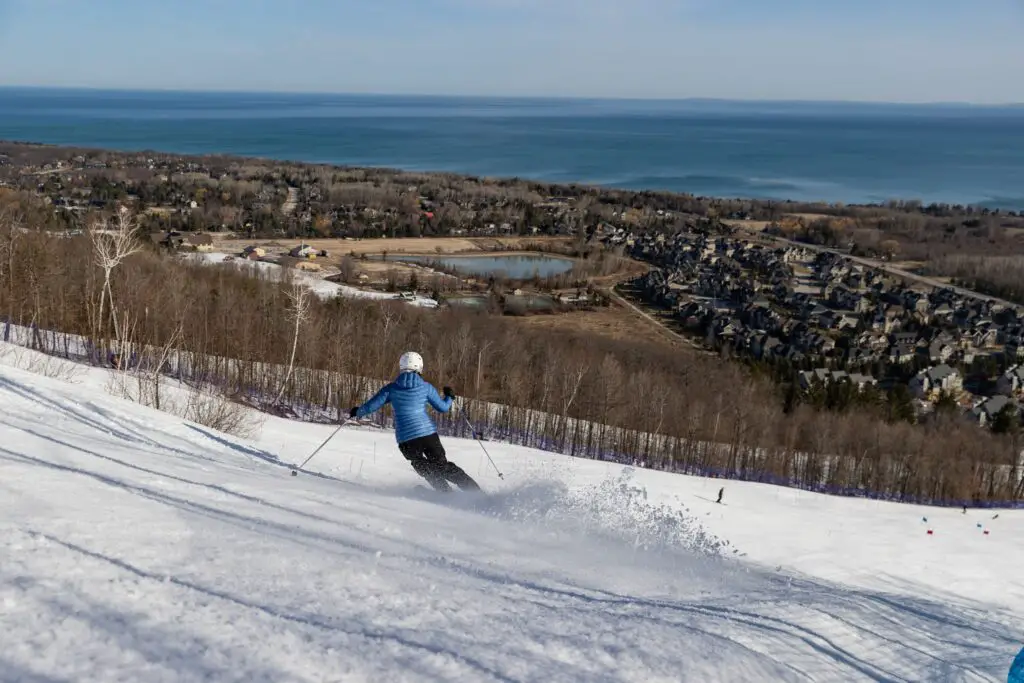 Person skiing at Blue Mountain, with views of Georgian Bay in the background